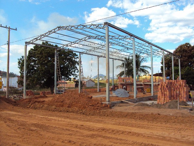 Estrutura metálica de um dos primeiros galpões do grupo em construção, em rua de terra